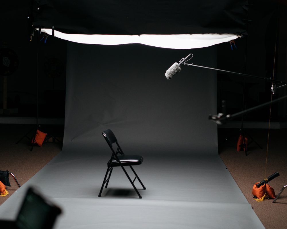 recording studio set up for video marketing content with chair, microphones and video cameras against a grey backdrop