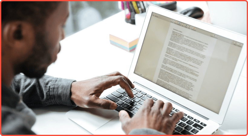Man working on website copy on laptop computer.